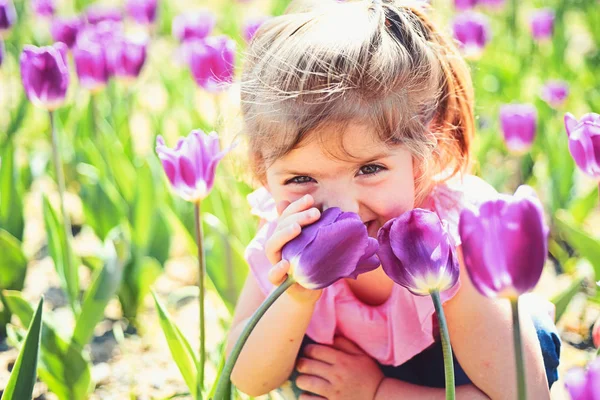 日当たりの良い春の少女。小さな子供。自然の美しさ。子供の日。顔のスキンケア。花にアレルギー。夏の女の子のファッション。幸せな子供時代。春のチューリップ。天気予報。美しい滞在 — ストック写真