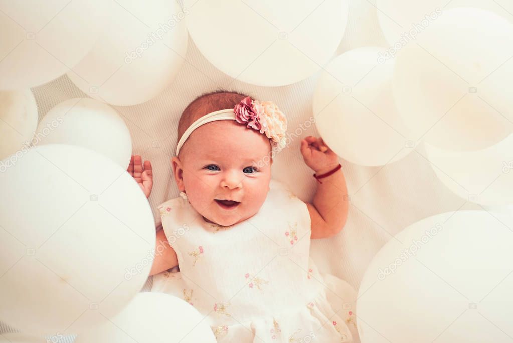 Tiny hand. Family. Child care. Childrens day. Small girl. Happy birthday. Sweet little baby. New life and birth. Portrait of happy little child in white balloons. Childhood happiness