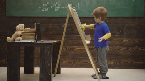 Primer plano de un chico que escribe con tiza en una tabla. Pequeño artista pinta sobre un fondo de madera. Concepto de arte. Educación en la primera infancia y concepto de juego. Creatividad y Arte Educativo . — Vídeos de Stock