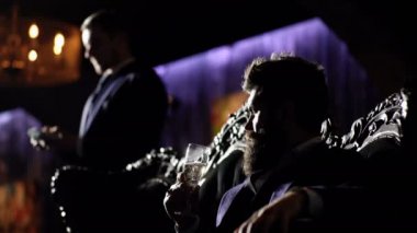 Para tutan takım elbiseli bir işadamı. Özgürlük, takım elbiseli parayla oturan başarı adamı. Zengin yaşam tarzı, profesyonel başarı, kar, finans kavramı. Ciddi yüzü ve güvenlik adamı sakallı adam.