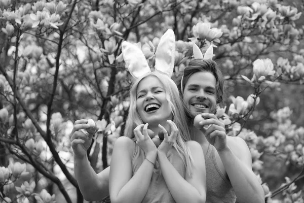 Casal Páscoa com ovos em orelhas de coelho em magnólia, Primavera — Fotografia de Stock
