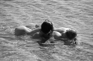 Sahilde günbatımı çıplak seksi genç çift.