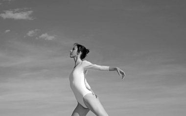 Güzel ve zarif. Sevimli bale dansçısı. Mavi gökyüzünde dans eden genç balerin. Dans giyen güzel bir kız. Klasik bale sanatı pratik. Konser performans dansı. Klasik dans stili