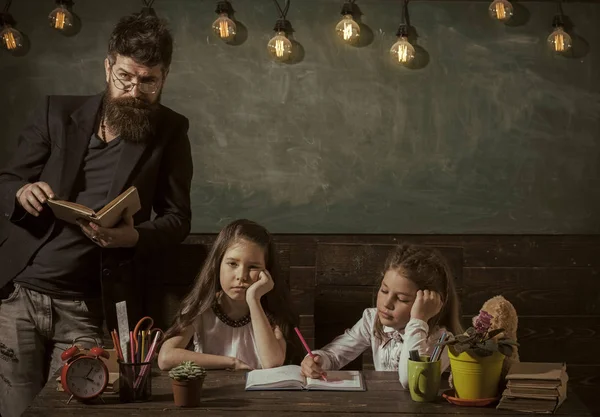 Βαρετό μάθημα ιδέα. Δάσκαλος και τα κορίτσια τους μαθητές στην τάξη, chalkboard σε φόντο. Άνδρας με γενειάδα διδάσκει μαθήτριες, διαβάζοντας το βιβλίο. Βαρεθεί και κουραστεί τα παιδιά ακούγοντας το δάσκαλο. — Φωτογραφία Αρχείου