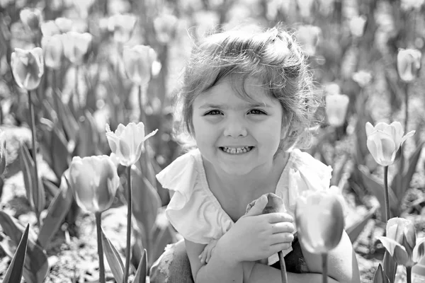 Positividade expressa. Criança pequena. Beleza natural. Dia das crianças. Menina de verão. Feliz infância. Tulipas da Primavera. previsão meteorológica. rosto e cuidados com a pele. alergia às flores. Menina na primavera ensolarada — Fotografia de Stock