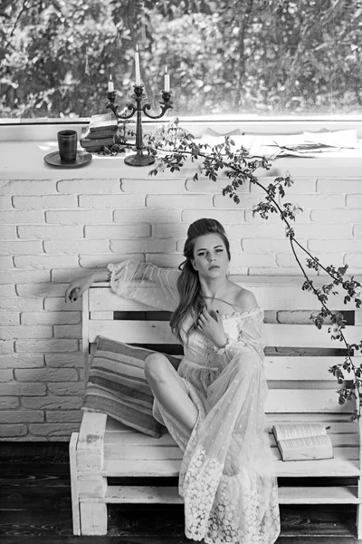 白いウェディング ドレスやレトロな髪型でかわいい女の子。かわいい女の子がベンチで本を読む. — ストック写真
