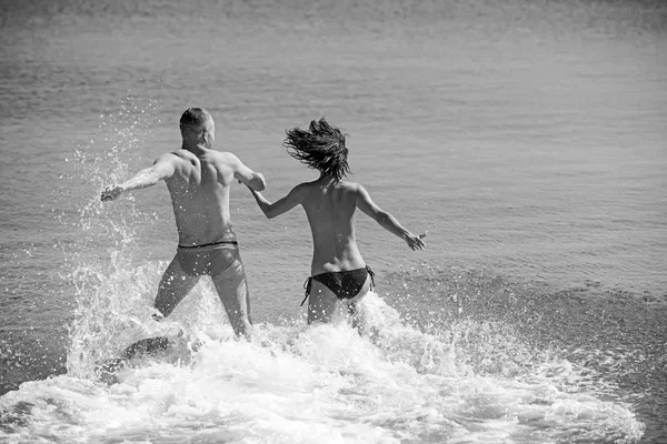 Familia feliz en la playa correr en agua de mar. — Foto de Stock