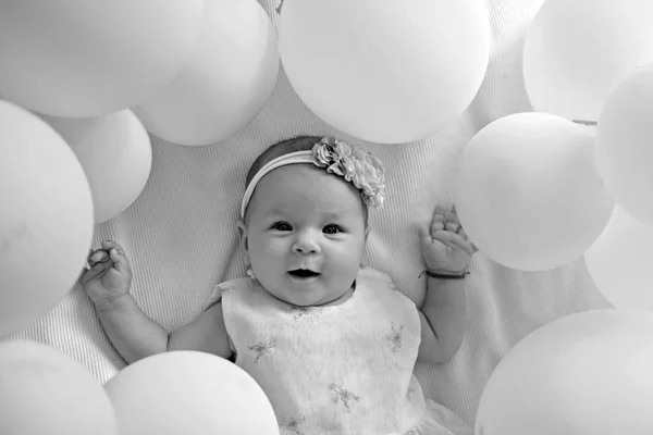 Aspetto un bambino. Ragazzina. Buon compleanno. Ritratto di bambino felice in palloncini bianchi. Dolce piccolina. Nuova vita e nascita. Felicità infantile. Famiglia. Assistenza all'infanzia. Giorno da bambini — Foto Stock