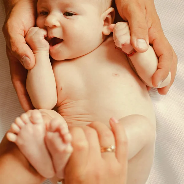 Händerna som hand. Nyfött barn i föräldrar händer. Nyfött barn gett kroppsmassage. Kroppen hudvård. Hålla babys hud frisk. Känner gillar i vår vård — Stockfoto