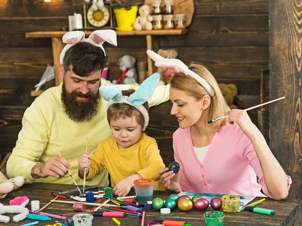Happy easter Mother, father and child enjoy painting Easter eggs.