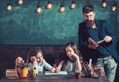 Öğretmen çocuklarla kitaplığındaki kitap okuma