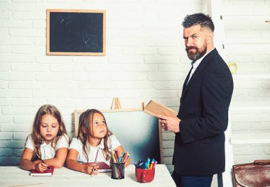 Genç adam için iki küçük kız kitap okumak.