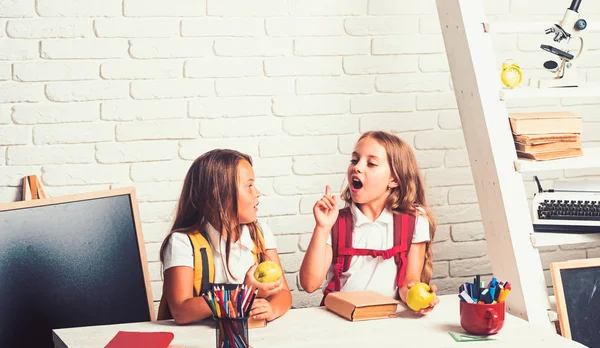 De schooltijd van meisjes. Kleine meisjes eet appel bij de lunchpauze. Gelukkig schoolkinderen op les in 1 september. Vriendschap van kleine zusters in de klas op de dag van de kennis. Terug naar school en huis het scholen — Stockfoto