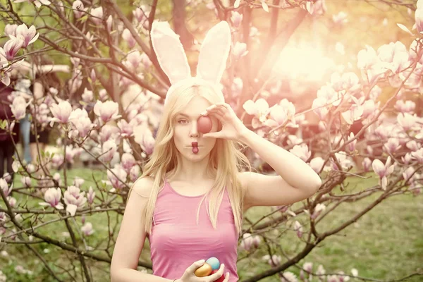 Sensual mujer en magnolia con huevos de colores . — Foto de Stock