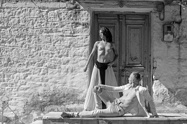 Sexy woman and man have sex game. sexy woman with muscular man at door of stony house wall in sunny summer outdoor.