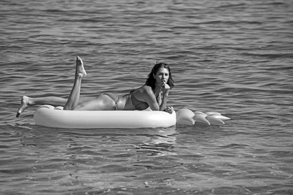 Mooi meisje om te zonnebaden op het luchtbed in de Oceaan. — Stockfoto