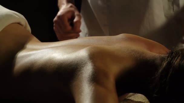 Gros plan du thérapeute faisant massage du cou sur la femme dans le spa sur fond noir. Massage des tissus profonds vue rapprochée. Charmant éclairage. Massage corporel au Spa Club. Lumière du soir . — Video