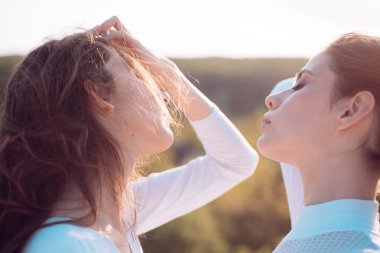 Saça gücünü vermek. Doğal dalgalı saç modeli ile Genç kızlar. Uzun saç stili ile sevimli kızlar. Sağlıklı saçlı genç kadınlar. Saç bakımı ve saç şekillendirme rutini
