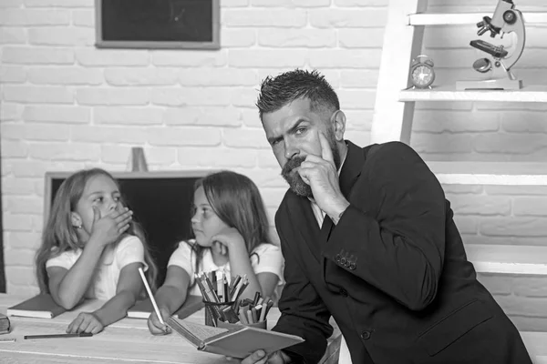 Schooltijd van zussen en vader in bibliotheek. Terug naar school en huis het scholen. Literatuur les en lezing grammaticaboek. Onderwijs in kennis dag. Leraar man gelezen verhaal naar meisjes eten apple — Stockfoto