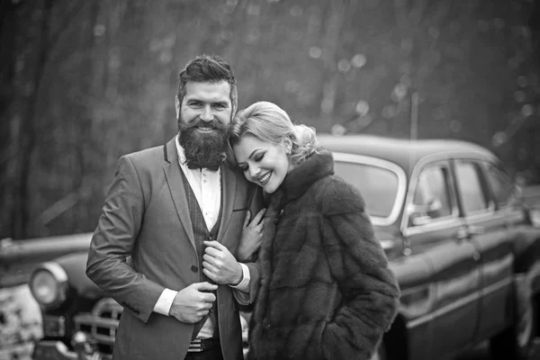 Retro couple at vintage car travelling in winter