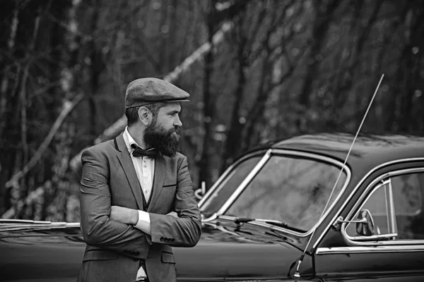 Hombre barbudo en el coche. Escolta o guardia de seguridad. Coche de recogida retro y reparación de automóviles por conductor mecánico. Llama al chico en auto vintage. Viajes y viajes de negocios o autoestop — Foto de Stock