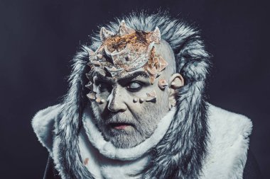 Beyaz sakallı komuta sizde canavar gibi giyinmiş. Karanlık sanatlara kavramı. Siyah arka plan, cehennemdeki şeytanlar kapatın. Dikenler veya siğiller kürk paltolu adam. Uzaylı, iblis, büyücü makyaj