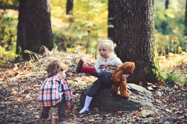 Çocuk kız ayakları üzerinde kırmızı bot koymak. Çocuk sonbahar ormanda yürüyüşe hazırlanıyor
