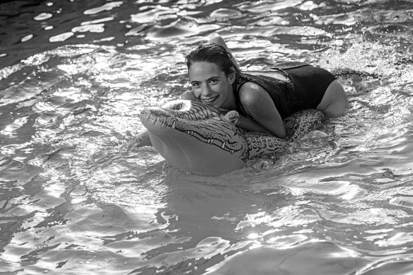 Belle femme dans l'eau avec crocodile gonflable vert — Photo
