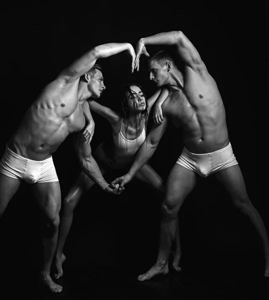 Twins mannen met gespierd lichaam en meisje. hart lichaamsvorm van sport mensen. Fitness en dieet. Valentijnsdag concept. Gymnastiek school en energie. Circus gymnasten op pilates of yoga opleiding — Stockfoto