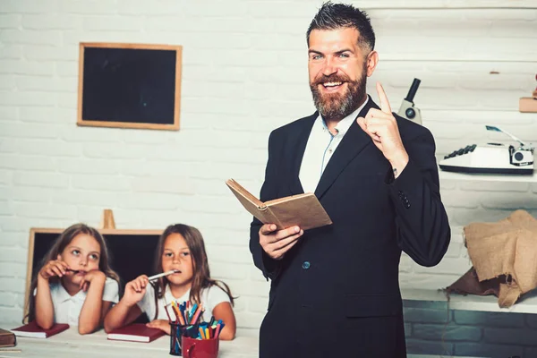 День образования в знаниях. образование в школе для маленькой девочки с бородатой учительницей, держащей книгу . — стоковое фото