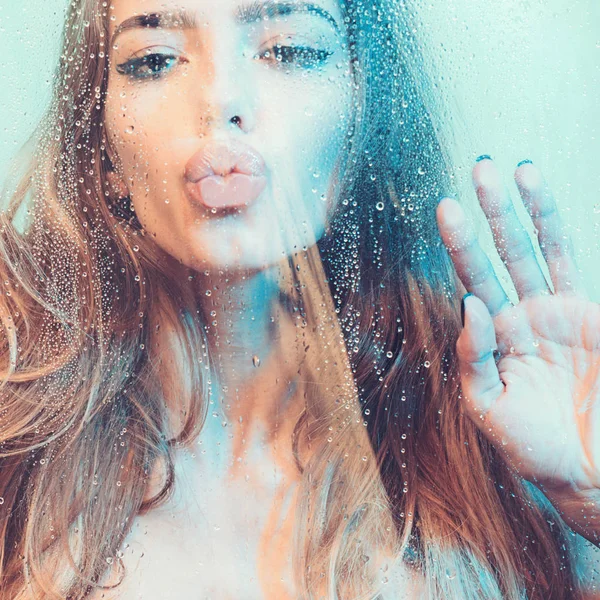 Sexy kobieta w prysznic. Atrakcyjna młoda kobieta nago pod woda spada na niebieskim tle — Zdjęcie stockowe