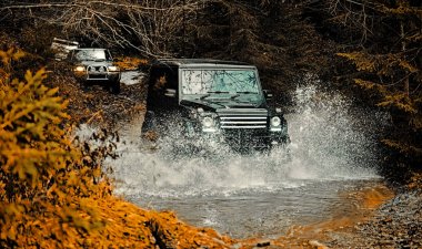 Off-road yarışlarında çamur ve su sıçraması. Dağlar manzara arasında Off road spor kamyon. Sefer offroader. Çamurlu bir tarlada izler. Yol macerası. Macera seyahat.