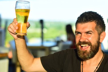Sakal adamı bira bardağından bira içiyor. Bira içen adam. Biralı adam.