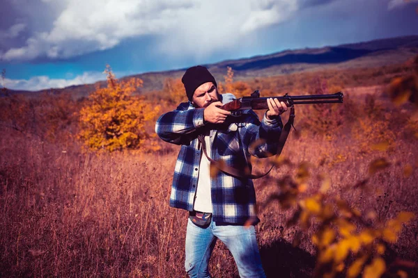 Podzimní Lovecká sezóna. Lovec s brokovnicí na lovu. Lovec se silnou puškou s rozsahem zaměřování zvířat. — Stock fotografie