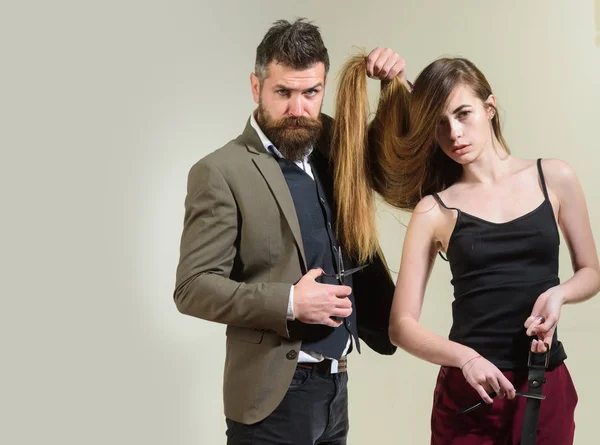 Cabeleireiro faz penteado uma mulher com cabelo longo. Mulher visitando o salão de cabeleireiro. Cuidados com o cabelo . — Fotografia de Stock