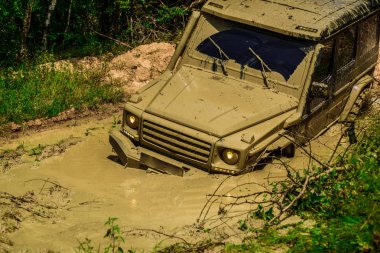 Off-road araç dağ yolunda gidiyor. Yarışa hazırlık lastikleri. Safari suv. Jeep açık maceralar. Çamur, ıslak çamur veya kil bir alanda off-road olduğunu.