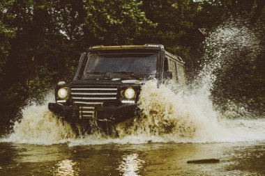 Çamurda izin iler. 4x4 Off-road suv araba. Çamurlu bir tarlada izler. Jeep bir su birikintisine çarptı ve bir toprak spreyi aldı. Offroad arabası. Safari. Dağlar manzara arasında Off road spor kamyon.