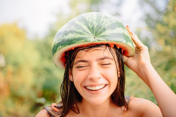 Retrato de una morena bastante graciosa. Descuentos de otoño en lencería. Venta de bragas para mujer. Gente loca. Alegre hermosa chica usando una sandía en su cabeza . — Foto de Stock