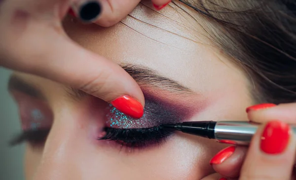 Ritratto ravvicinato. Processo di preparazione del trucco. Un truccatore professionista dipinge modelli di ciglia in studio. — Foto Stock