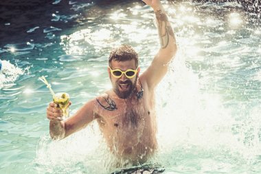 Genç adam denizde kokteyl ile Yüzme havuzunda atlama.