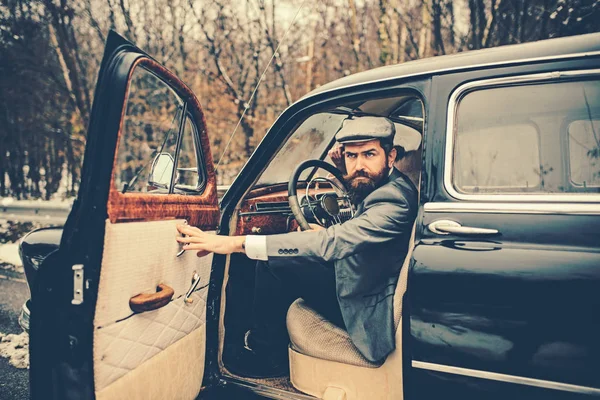 Travel and business trip or hitch hiking. Escort man or security guard. Call boy in vintage auto. Bearded man in car. Retro collection car and auto repair by mechanic driver