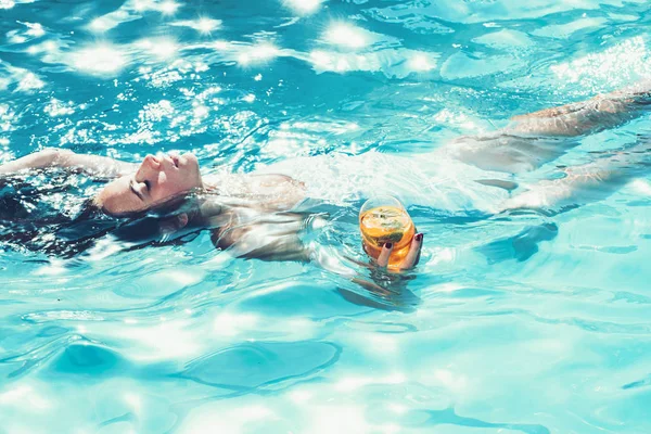 Nadar y celebrar cóctel con fruta en la mano de chica en la piscina en las maldivas. cóctel con mujer nadadora en la piscina — Foto de Stock