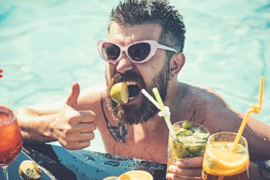 Miami beach veya Maldivler tatil yaz. Adam yüzme ve içecek alkol. Havuzda sakallı adam meyve kokteyli. Havuz partisi, vitamin ve diyet. Deniz ve spa resort sakin ol.