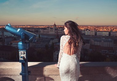 Beyaz elbiseli Genç kız üzerinde şehir skyview Dürbünle bak. Turistik teleskop kadınla