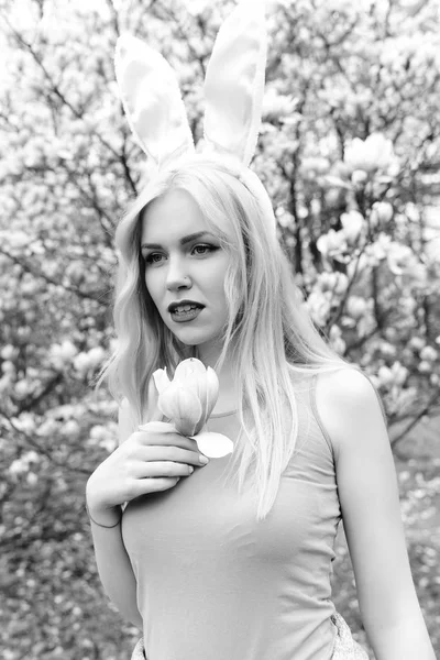 Pasen mode, jonge vrouw met magnolia bloemen in lentetuin — Stockfoto