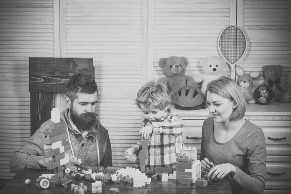 Отец, мать и сын в игровой комнате на светлом деревянном фоне. — стоковое фото