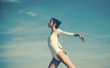 Her harekette güzellik. Dans giyen güzel bir kız. Mavi gökyüzünde dans eden genç balerin. Sevimli bale dansçısı. Klasik bale sanatı pratik. Konser performans dansı. Klasik dans stili