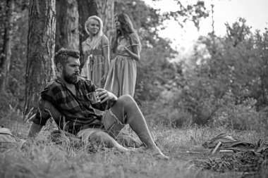 Arka plan bulanık kadın ile adam içki çay şenlik ateşi, sakallı. Hippi sakal oturup kamp ateşi ile. Arkadaşlar ormanda kamp keyfini çıkarın. Yaz tatil kavramı. Kamp, yürüyüş ve turistik