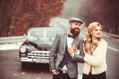 Retro arabaya yürürken bir kolu büyüleyici bir gelin damat tutar.