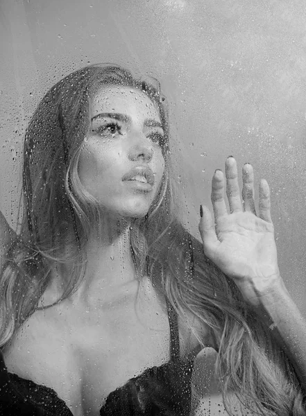 Fenêtre avec gouttes d'eau avant fille avec maquillage. feuille de fenêtre dans les mains de femme sexy ou modèle de mode . — Photo